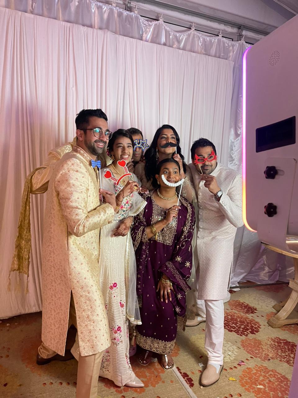 Wedding guests posing with props at the TuneBox Photo Booth