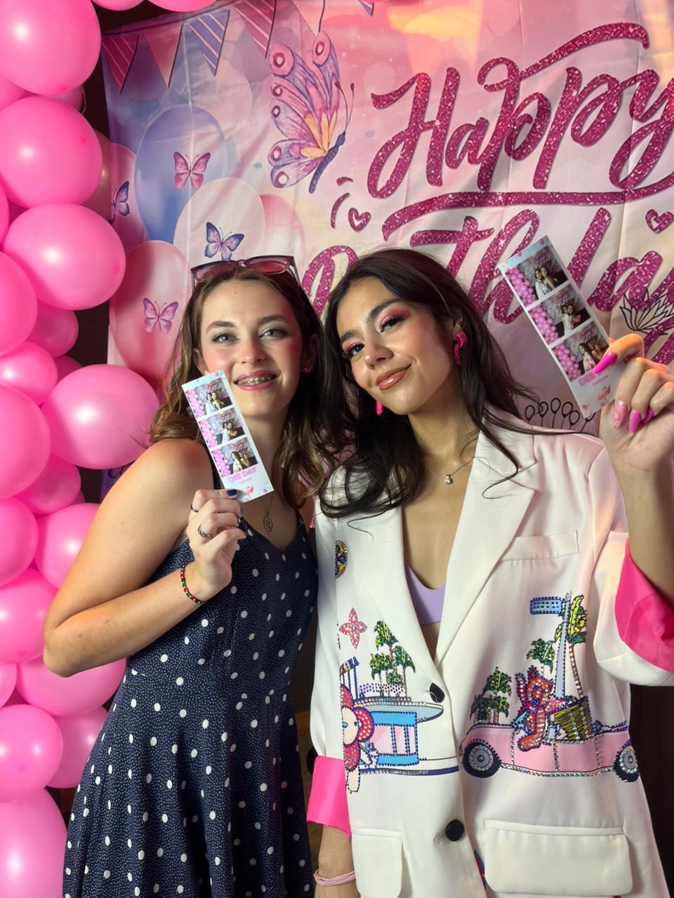 Guests holding TuneBox photo strips at a birthday party